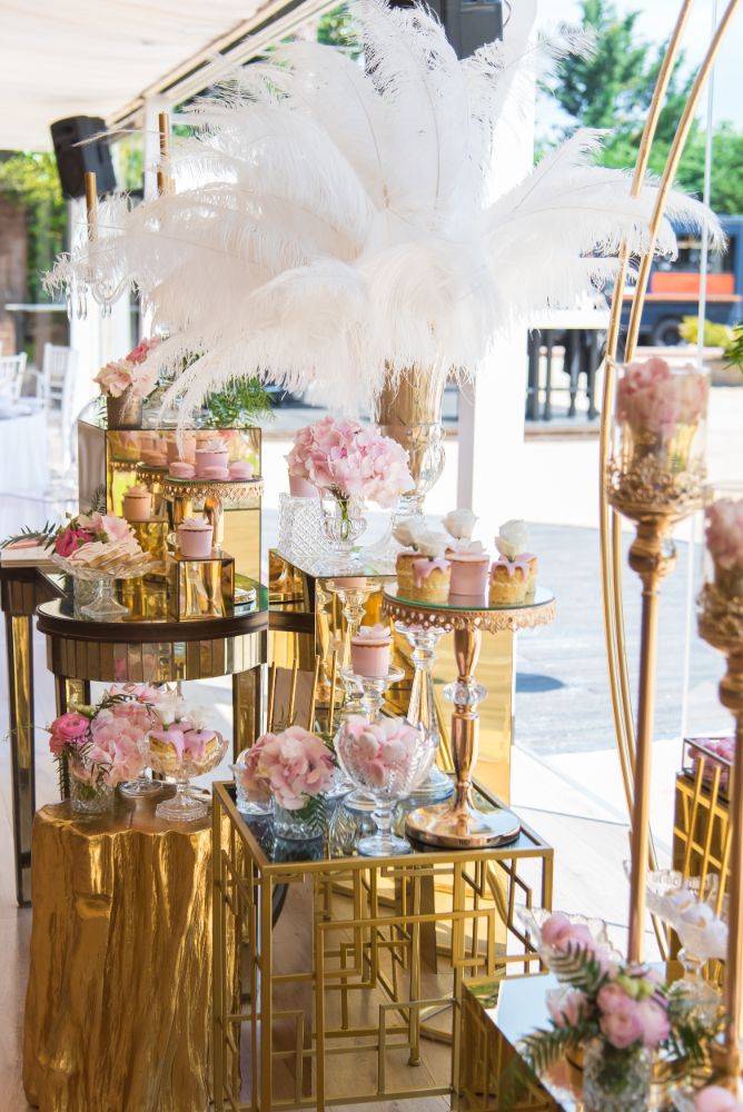 Wedding candy bar decoration with feathers, pink roses and gold details