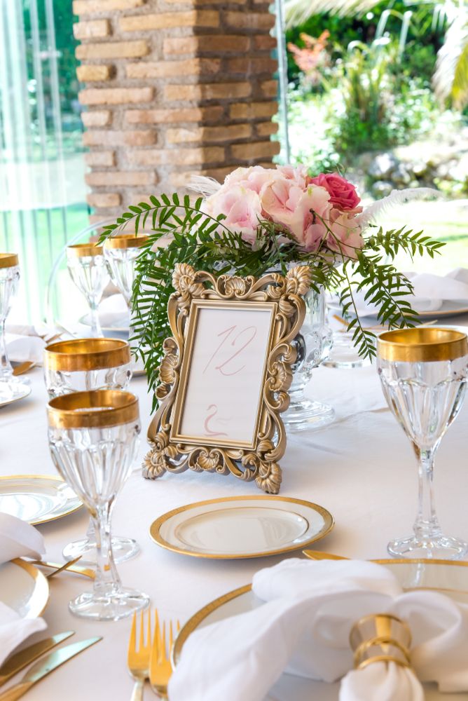 Wedding table with flowers, plates, cutlery, and a frame with the table number