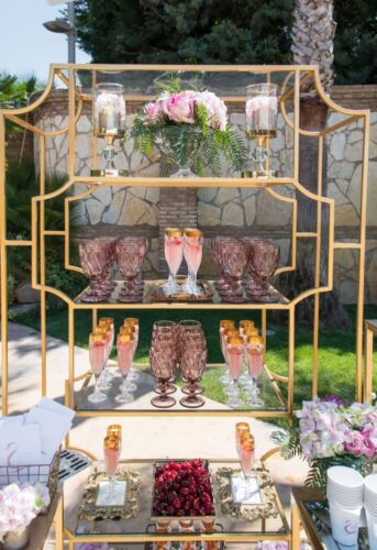 Wedding refreshment stand, with refreshment drinks, gold details, fresh cherries, glasses, and roses
